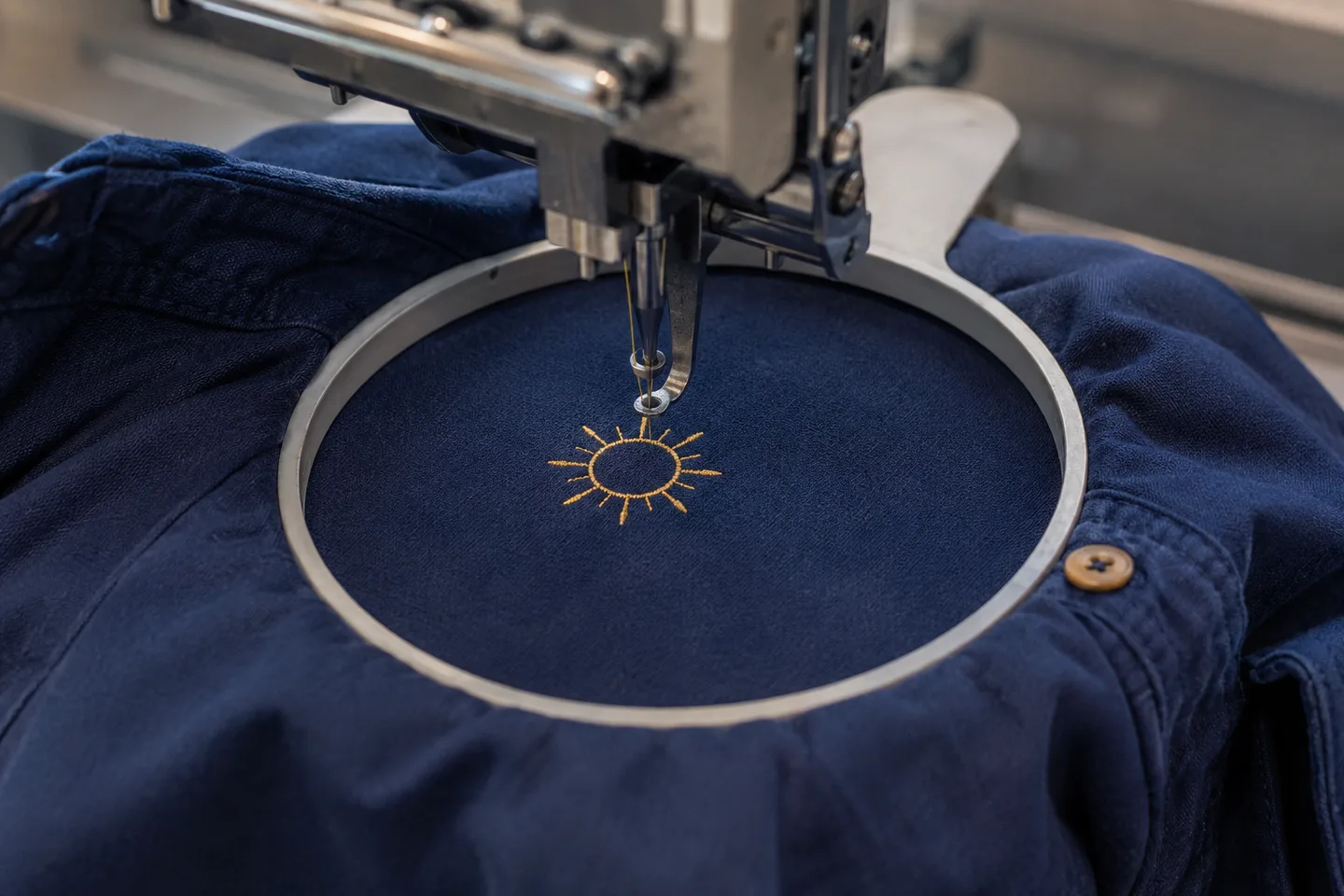 Illustrative image of a sun motif being embroidered on navy fabric
